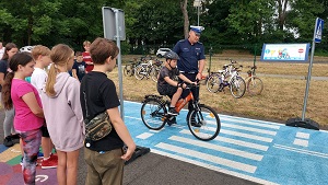 Policjant wraz z uczniami zdającymi egzamin na kartę rowerową